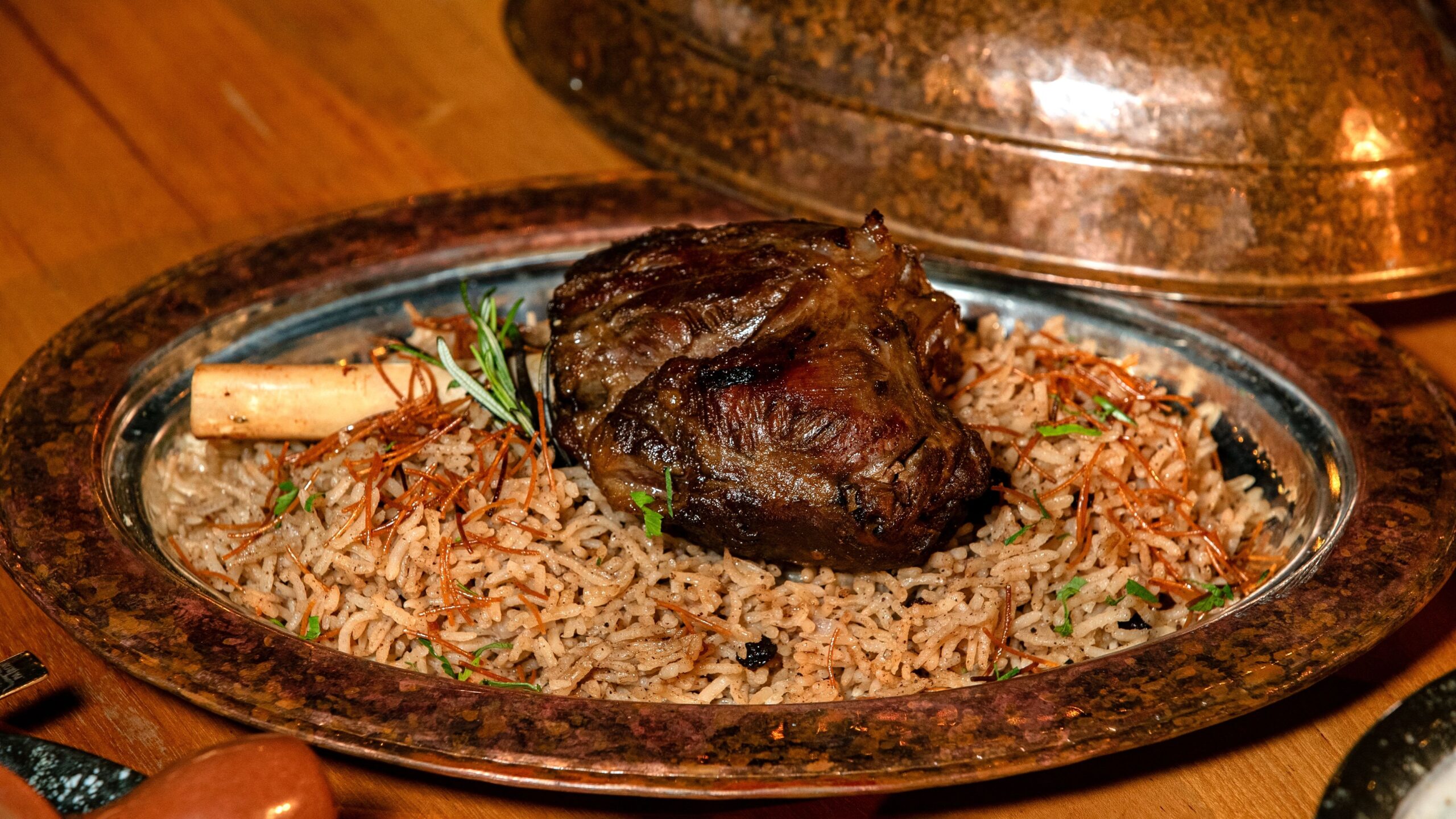 A sumptuous lamb shank served on a bed of aromatic basmati rice with herbs.